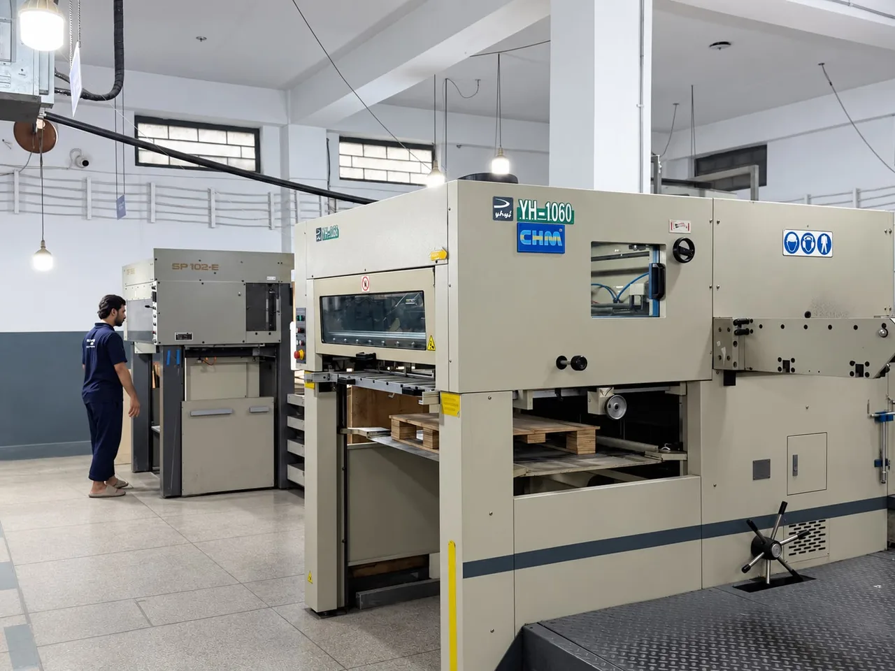 Automatic die-cutters, a YH-1060 and an SP 102-E, on the factory floor.