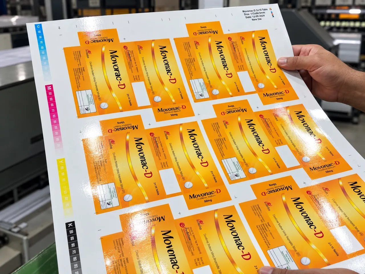 Gloss-coated sheet of orange Movonac-D cartons with its colour bar.